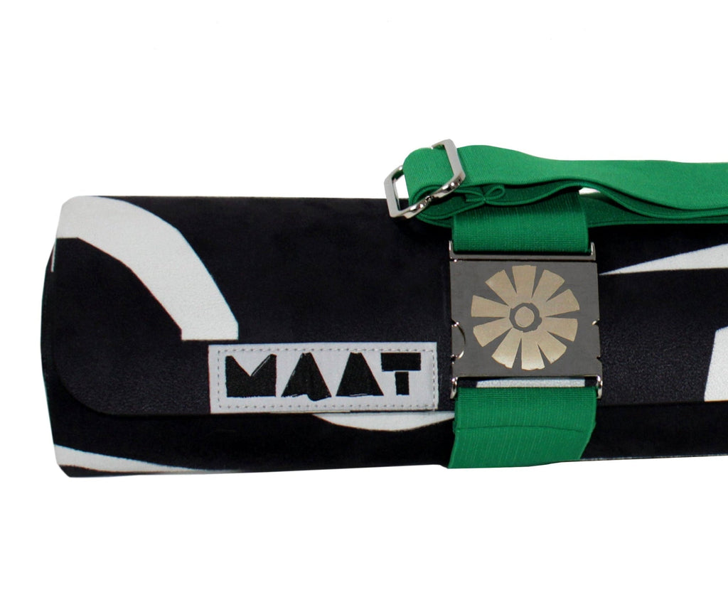 Roll-up mat with green strap and 'MAAT' branding on a white background