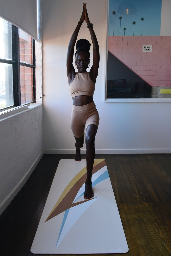 Girl standing and jumping on the mat with two arms stretch upwards to the ceiling