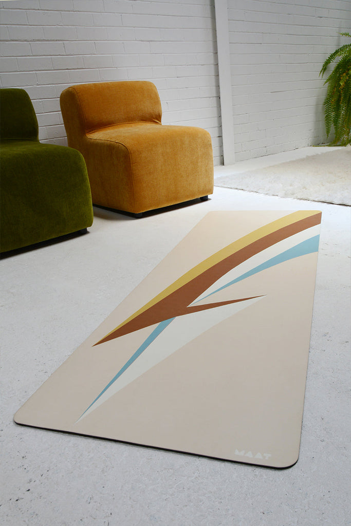 Mat laying on the floor among green and yellow sofas