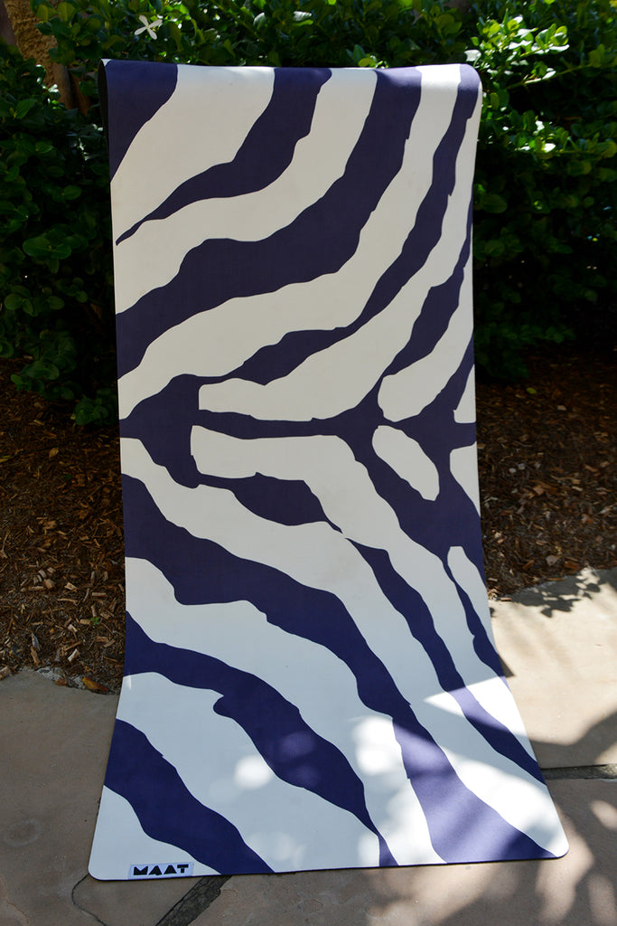 yoga mat draped on a tree branch outside