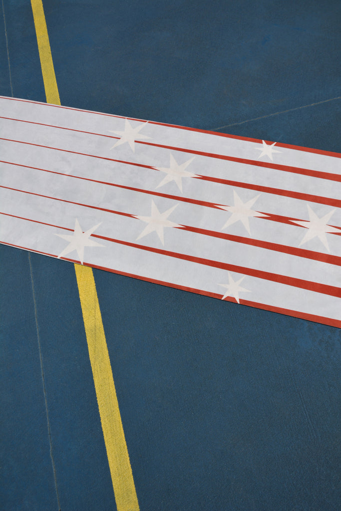 Product Shot half flatlay yoga mat star print blue tennis court yellow line floor