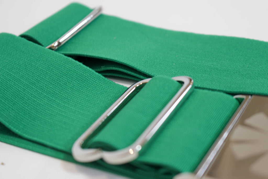 Green belt with silver buckle on a white background