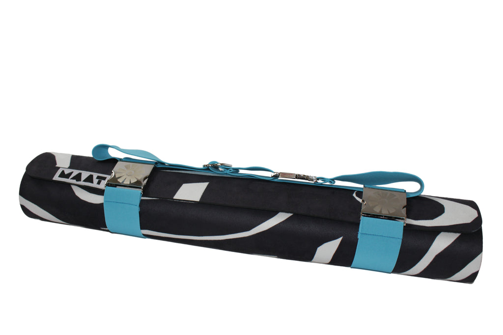 Blue strap around rolled up black and white yoga mat. 