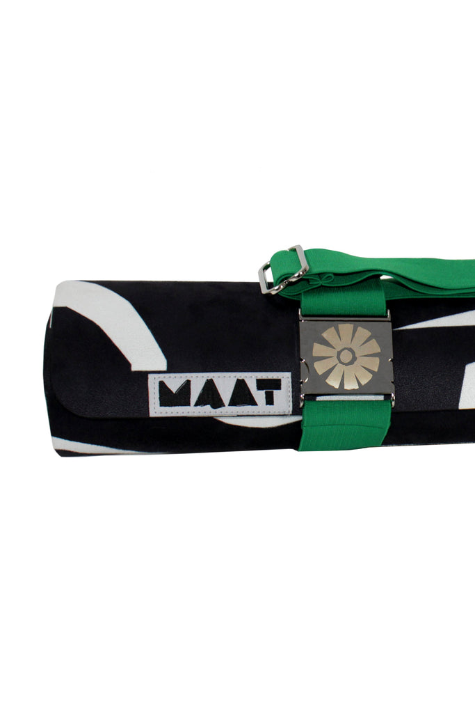 Roll-up mat with green strap and 'MAAT' branding on a white background