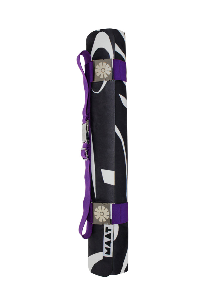 Purple strap around black and white yoga mat 