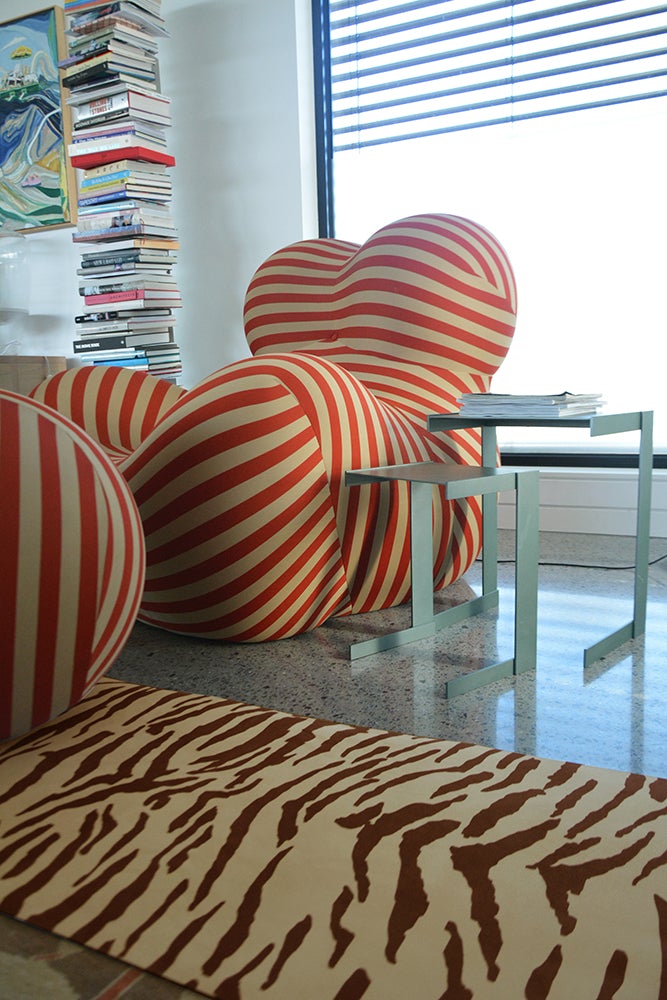 Mat laying on the floor among red-white stripe heart shape cushions