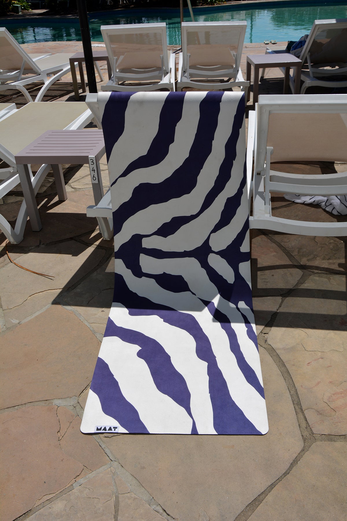 Yoga mat draped on the back of a pool chair